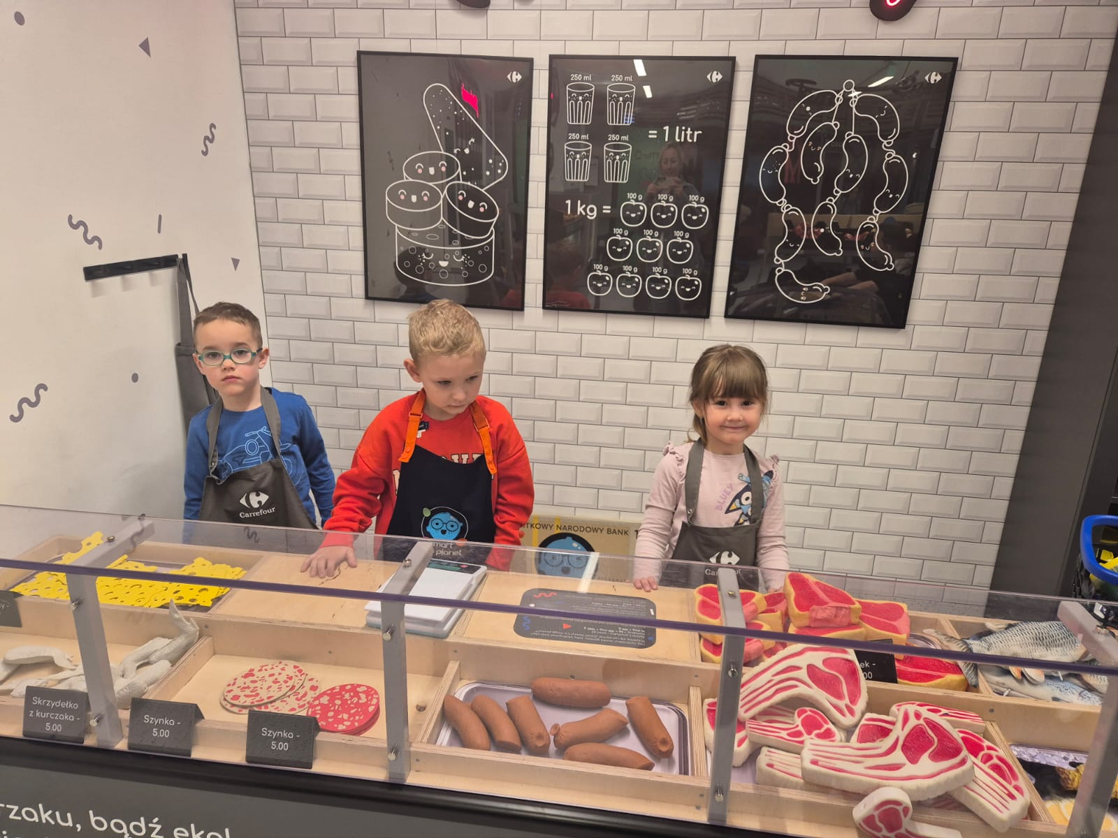 Dzieci sprzedają na stoisku mięsnym.