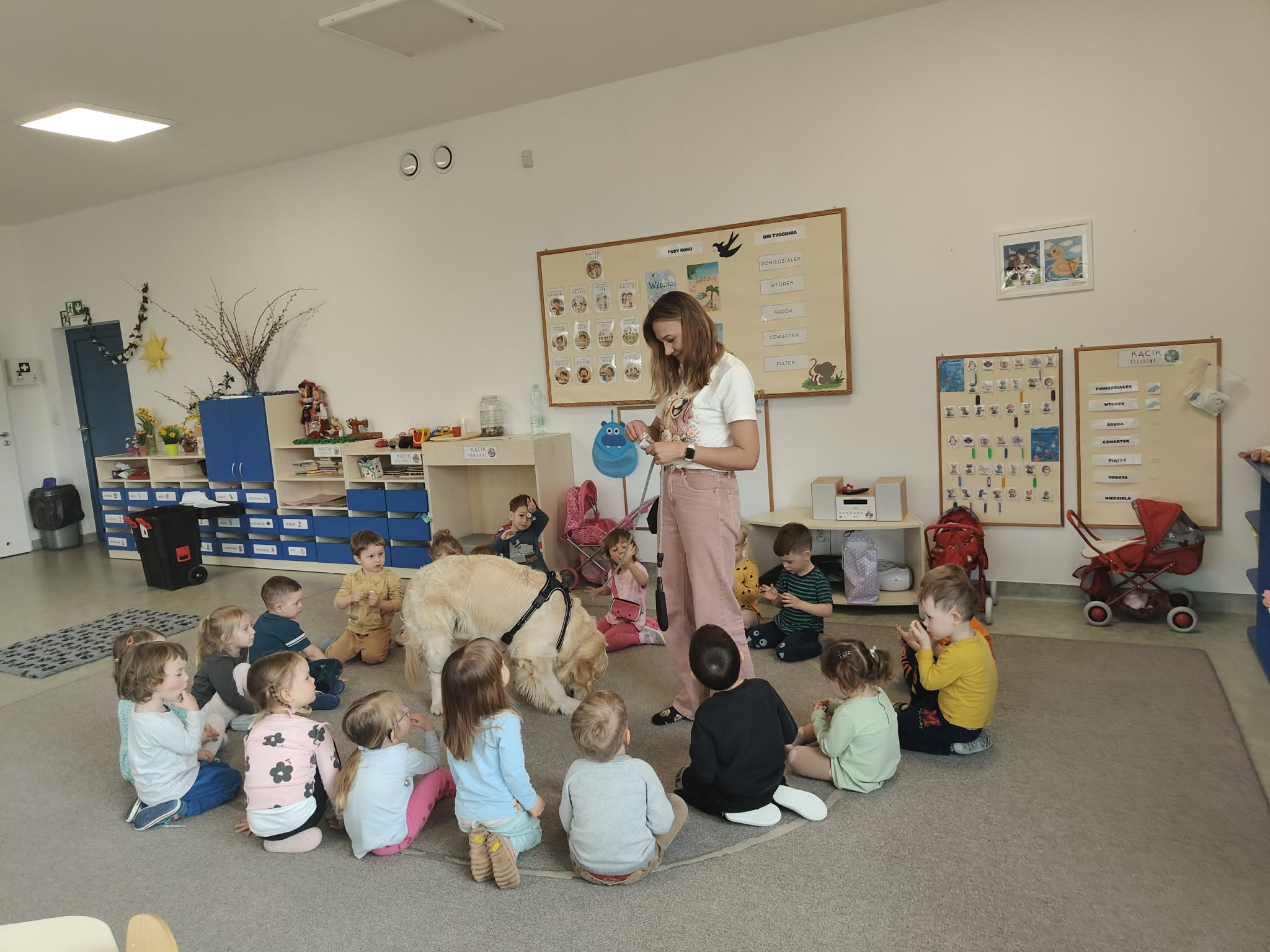 Grupa przedszkolaków zapoznaje się z psem.