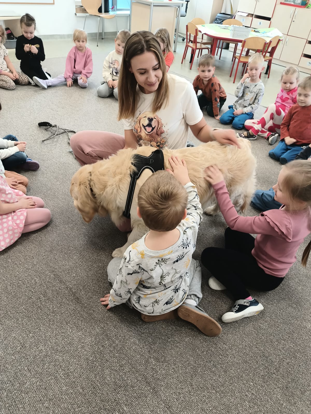 Dzieci głaszczą psa.