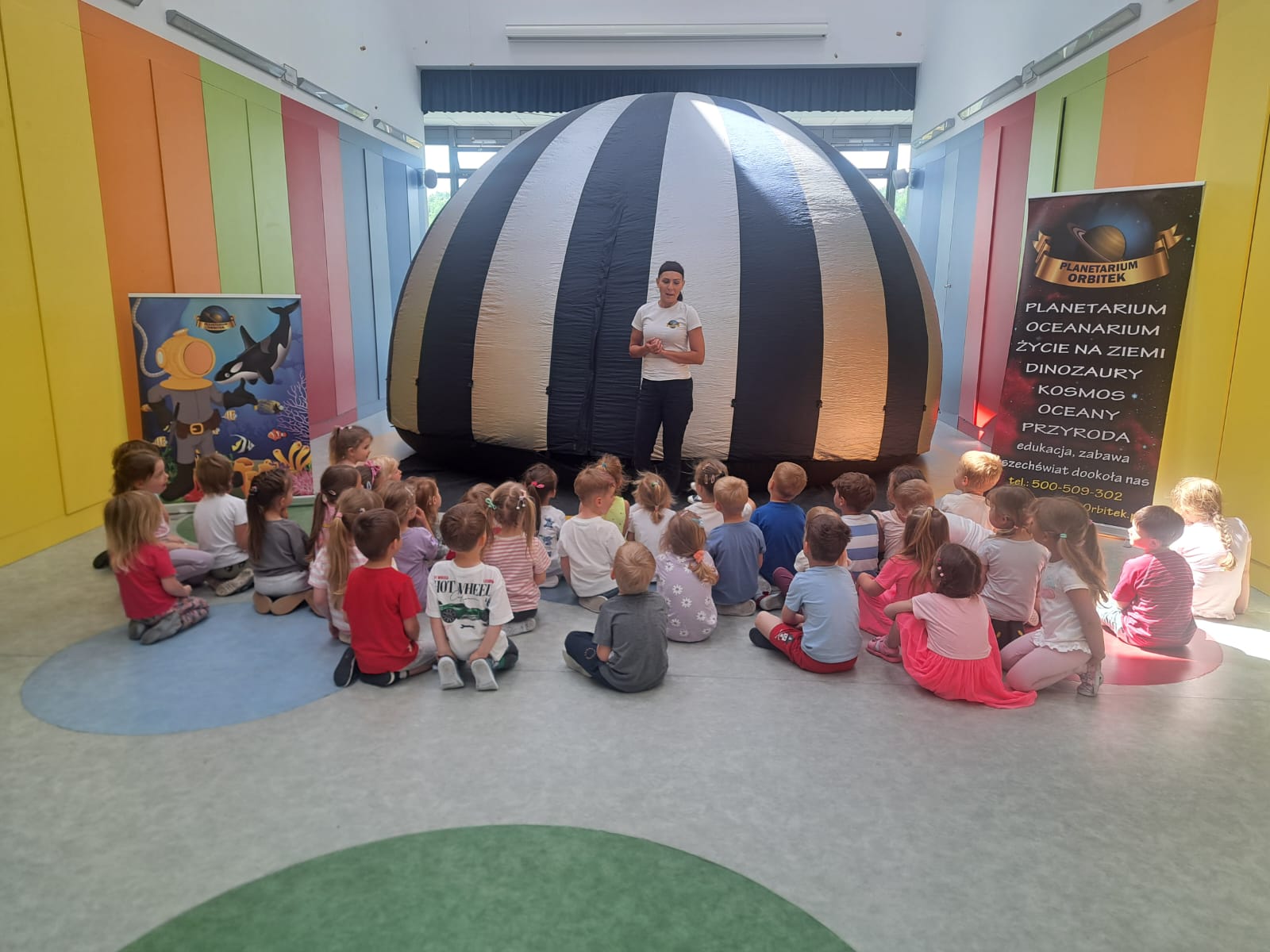 Przedszkolaki słuchają zasad korzystania z mobilnego planetarium.