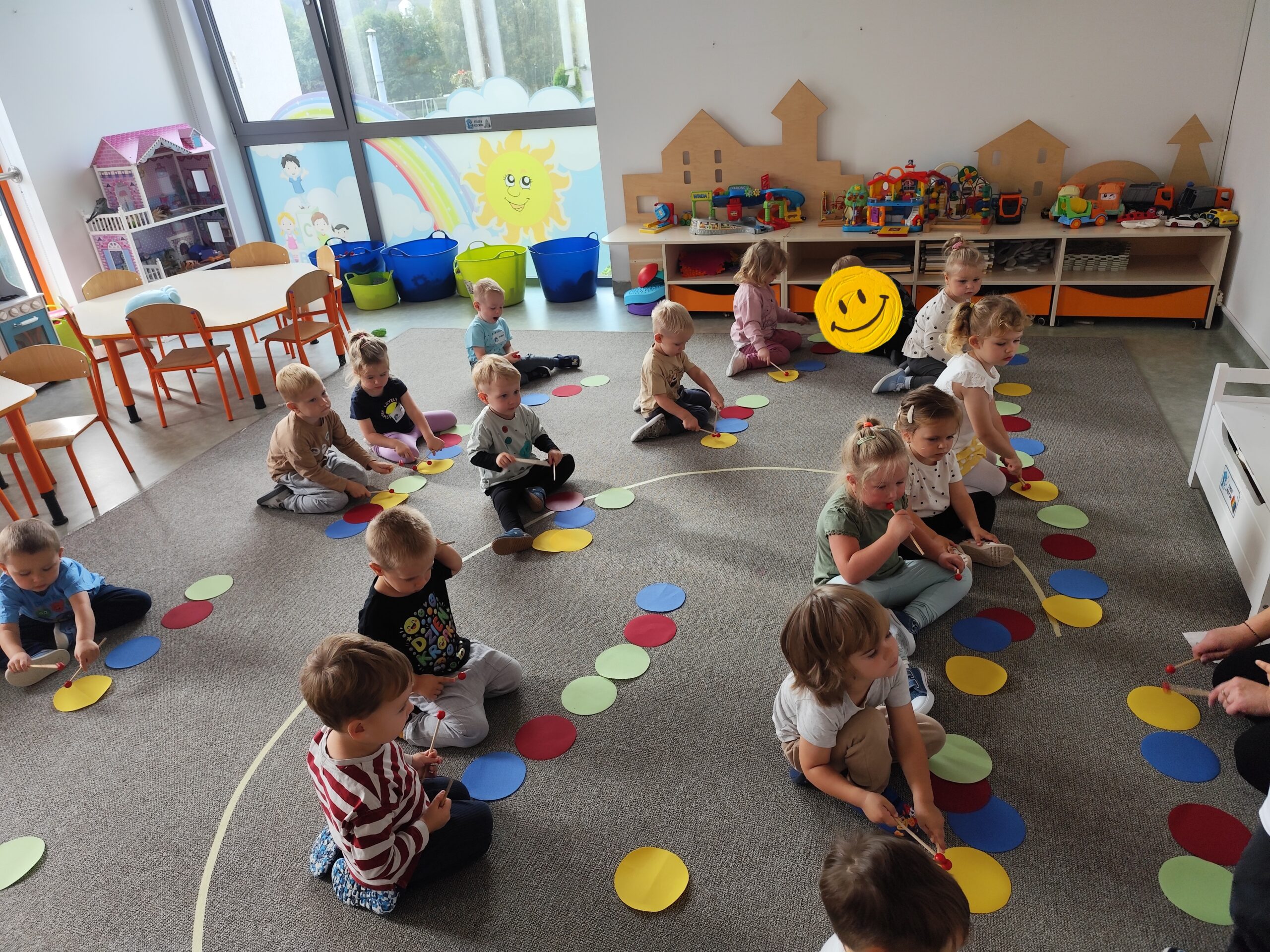Dzieci wystukują rytm paleczkami.